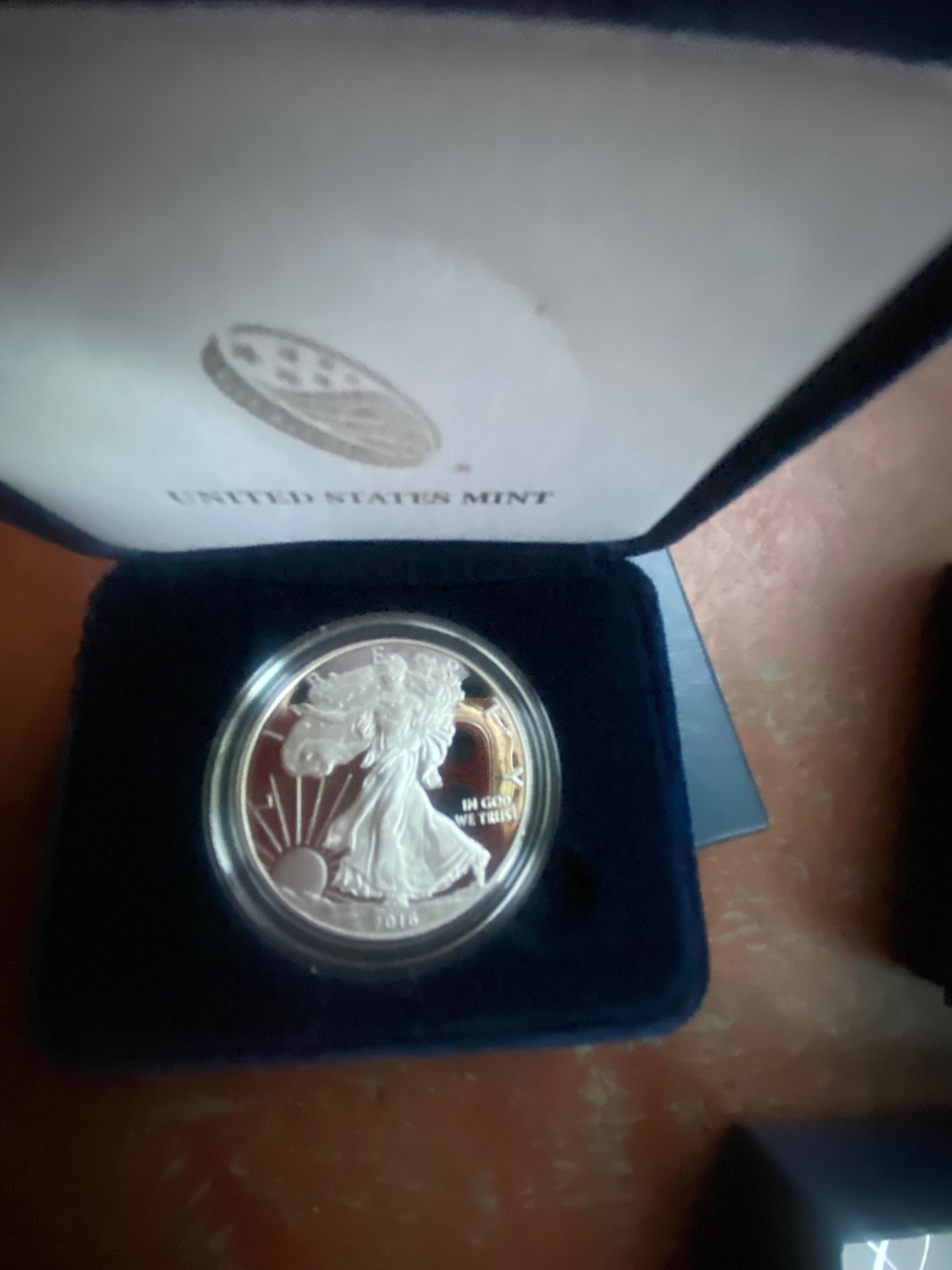 American Silver Eagle 1 oz Proof — U.S. Mint Original Packaging, Certificate of Authenticity (silver) — obverse shown in hand, photographed in hand at Capstone Metals.