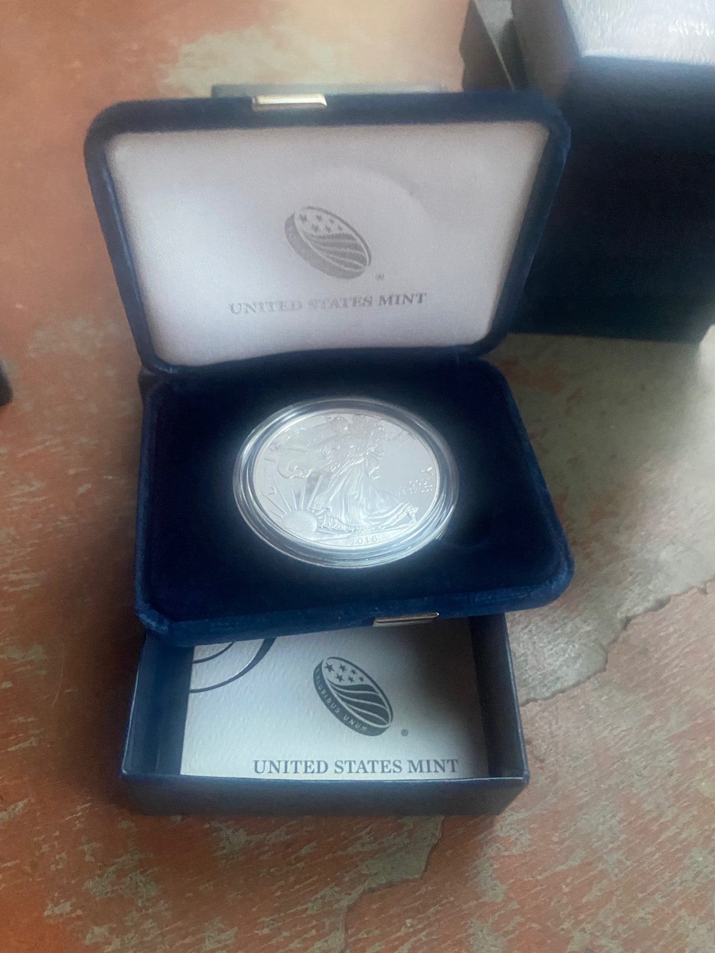 American Silver Eagle silver proof coin in its United States Mint velvet case with the certificate booklet in the drawer